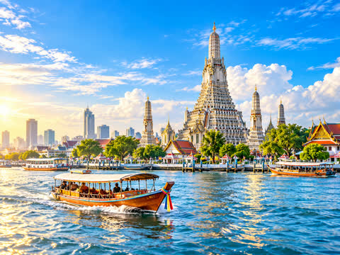 Wat Arun on the Chao Phraya river in Bangkok with a passenger boat